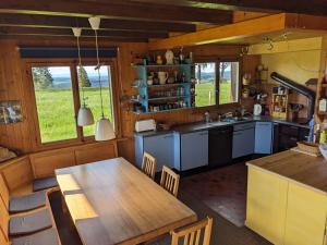 a kitchen with a wooden table and a dining room at Chalet Les Bises in Courtelary