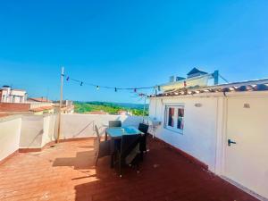 a patio with a table and chairs on a roof at Habitación con baño y cocina in Caudiel