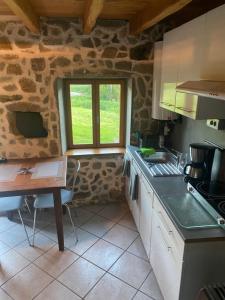 a kitchen with a table and a counter top at Maisonnette chaleureuse de 35m2 in Miremont