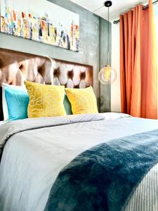 ein Schlafzimmer mit einem Bett mit gelben und blauen Kissen in der Unterkunft Casa YON pet friendly, Netflix,free parking, factura, high speed wifi, Amazon Prime in Municipio Cuautitlán Izcalli