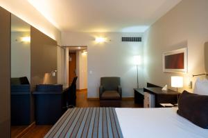 Una habitación de hotel con una cama, un escritorio y una silla. en Sol Alphaville Hotel & Residence, en Barueri