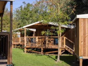 a wooden pavilion with chairs and a tree at Camping 4 étoiles - Piscine - cbgcb0b in Saint-Jean-de-Monts