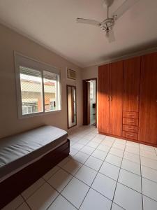 a bedroom with a bed and a ceiling fan at Apartamento Praia da Enseada in Guarujá +19 photos