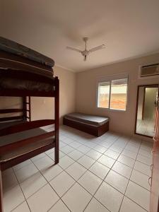 a bedroom with two bunk beds and a window at Apartamento Praia da Enseada in Guarujá