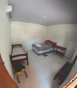 a room with two beds and a table and chairs at Hostel Lençóis em Santo Amaro MA in Santo Amaro