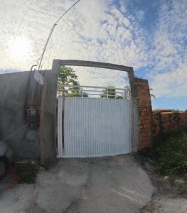 a white garage door with a gate in a brick wall at Hostel Lençóis em Santo Amaro MA in Santo Amaro