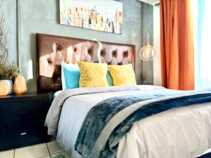 ein Schlafzimmer mit einem großen Bett mit gelben und blauen Kissen in der Unterkunft Casa YON pet friendly, Netflix,free parking, factura, high speed wifi, Amazon Prime in Municipio Cuautitlán Izcalli