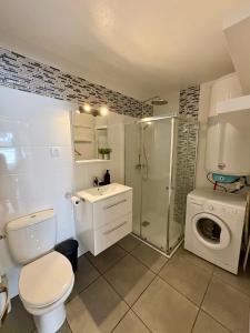 a bathroom with a shower toilet and a washing machine at Studio entre lac et océan à Hossegor in Soorts-Hossegor