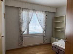 a bedroom with a window with curtains and a bed at Dream Big House Tervaharju in Kemi +5 photos