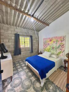 a bedroom with a bed with a blue comforter at Casa Café - Aconchego na Floresta - Rota do Vinho in São Roque