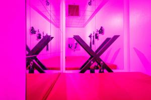 una stanza con una stanza rosa con un tavolo di Nuit Sauvage - Love Room pour Fantasmes Réalisés a Thiers-sur-Thève