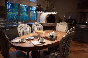 a kitchen with a wooden table with chairs and a dining room at Hotel MasClara in Villa de Leyva