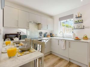 eine Küche mit weißen Schränken und einem Tisch mit Orangensaft in der Unterkunft 1 Bed in Broadstairs 89391 in Broadstairs