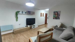 a living room with a couch and a flat screen tv at Apartamento en Isla Cristina in Isla Cristina