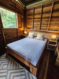 a bedroom with a bed in a wooden cabin at La Casa Del Mono in Minca +26 photos