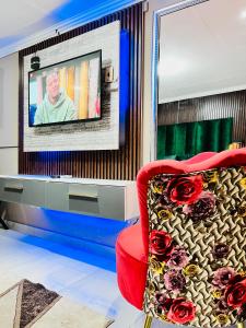 un soggiorno con sedia rossa e TV di Executive Galaxy Guest House Nkowankowa a Nkowakowa