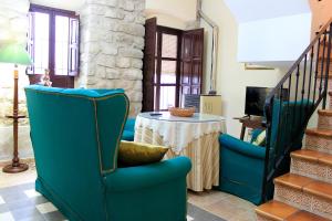 sala de estar con sillas azules y mesa en La Muralla, en Sabiote
