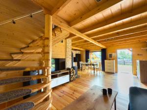 a wooden house with a living room and dining room at Domy z sercem in Pilchy