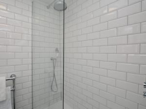 a bathroom with a shower with white tiled walls at 2 Bed in Burton Bradstock DC166 in Burton Bradstock +17 photos