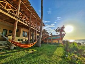 a hammock on the side of a house next to the beach at Mancora Beach Hotel in Máncora