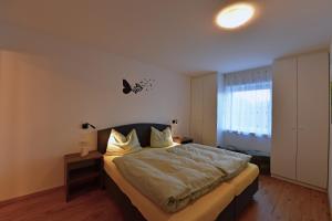 een slaapkamer met een groot bed en een raam bij Lärchenheim Appartment in Castelrotto