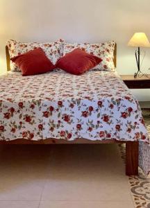 サンタ・ブランカにあるPatizal - Santuário de animaisの花柄の掛け布団と枕2つが備わるベッド1台