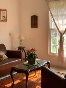 サンタ・ブランカにあるPatizal - Santuário de animaisのソファとテーブルのあるリビングルーム +1枚の写真