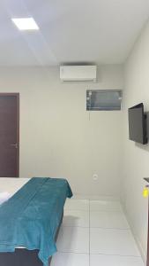 a hospital room with a bed and a tv at Hotel Maria Araújo in Arapiraca