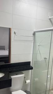 a bathroom with a toilet and a glass shower at Hotel Maria Araújo in Arapiraca