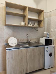 a small kitchen with a sink and a microwave at وادي العقيق 201 in Medina +23 photos