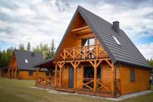 a log cabin with a black roof at Domy z sercem in Pilchy