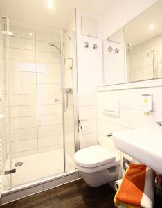 a bathroom with a shower and a toilet and a sink at Akzent Hotel Am Burgholz in Tabarz