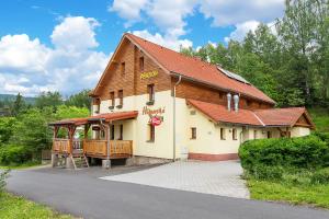 a building with a sign on the side of it at penzion Hamerská Jizba in Nové Hamry