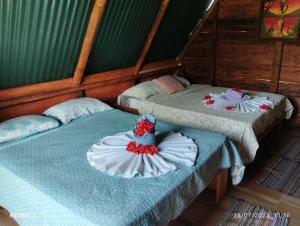 two twin beds in a room at Arenal Base Camp in El Castillo de La Fortuna