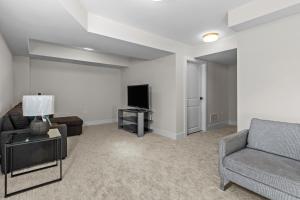 Una sala de estar con un sofá y un televisor. en Luxury Townhome, en Oakville