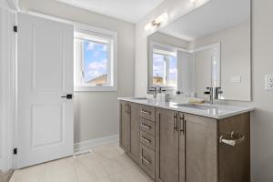 Un baño con lavabo y dos ventanas. en Luxury Townhome, en Oakville