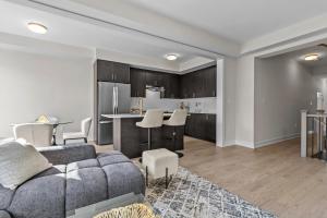 Una sala de estar con un sofá y una cocina. en Luxury Townhome, en Oakville 22 fotos más