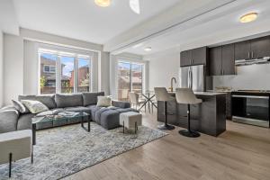 Una sala de estar con un sofá y una cocina. en Luxury Townhome, en Oakville