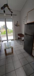 a kitchen with a stainless steel refrigerator and a table at Armonia - home in Mola Kalyva