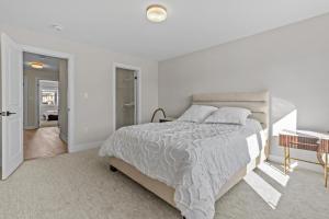 Un dormitorio blanco con una cama grande y un escritorio. en Luxury Townhome, en Oakville