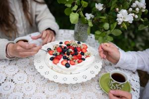 a group of people sitting at a table with a cake at Jennin Majatalo in Reisjärvi