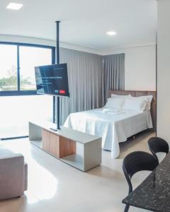 a bedroom with a bed and a flat screen tv at Loft Bamberg 101 in Pomerode