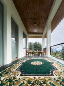 a patio with a table and chairs on a rug at Tranquil House Manali in Haripūr +32 photos