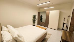 a bedroom with a white bed and a mirror at شقق سكنية مفروشة فاخرة - مكة الشرائع in Ash Sharāʼi‘