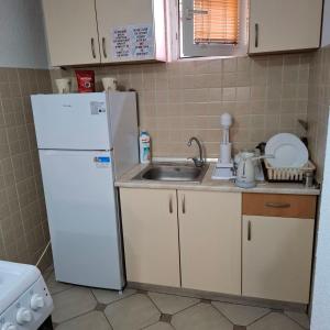 a kitchen with a white refrigerator and a sink at Villa Kaya in Ohrid
