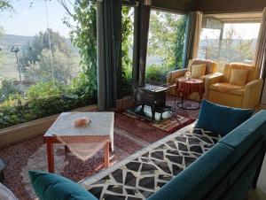 ein Wohnzimmer mit Sofa und großem Fenster in der Unterkunft בקתה בגלקסיה in Madschdal Schams