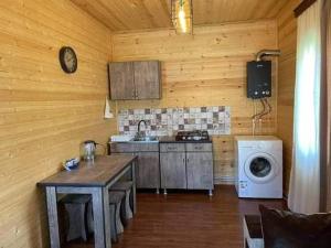 a kitchen with a stove and a washing machine at Xevi cottage in Ach'khoti