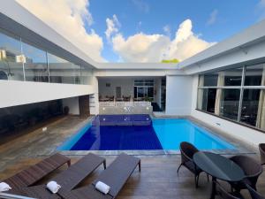 an indoor swimming pool with chairs and a house at Arituba Park Hotel in Natal