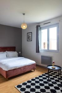a bedroom with a bed and a window and a table at Maison près de Disneyland in Saint-Germain-sur-Morin
