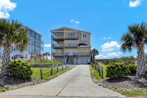 a building on the beach with palm trees and a sidewalk at 116 Scotch Bonnet Drive - Better Together in North Topsail Beach